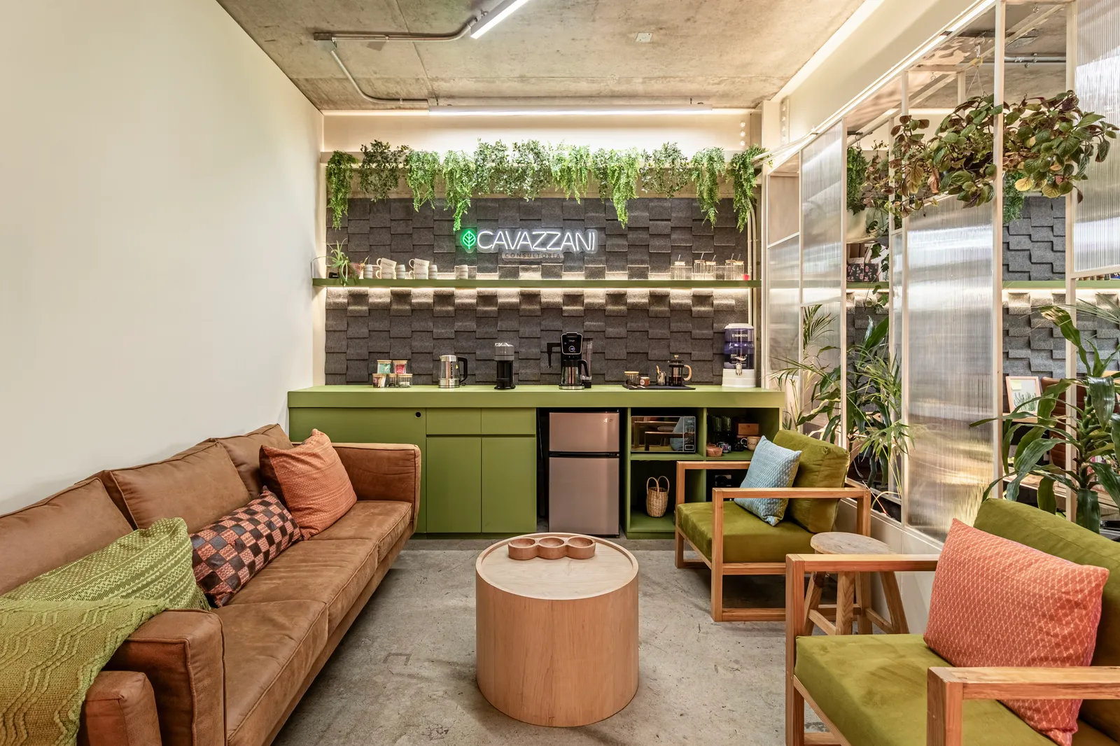 Sala de espera con sofá y vegetación en la oficina de Andrea Cavazzani
