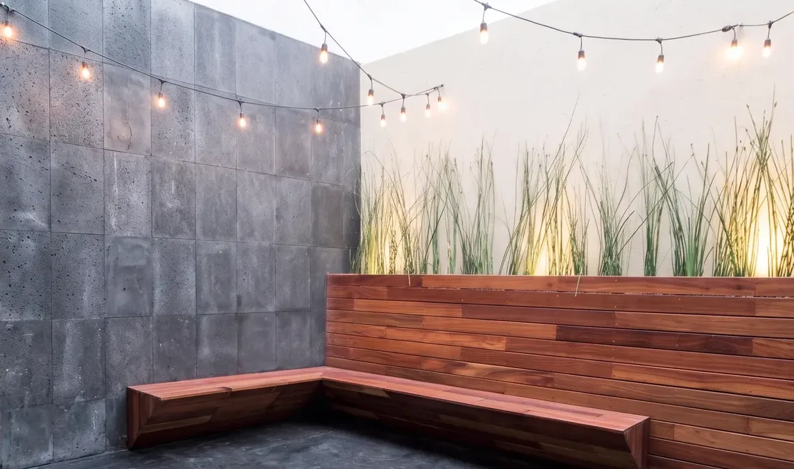 Terraza renovada de la casa en San Jerónimo, con banca de madera, luces de exterior y jardinera