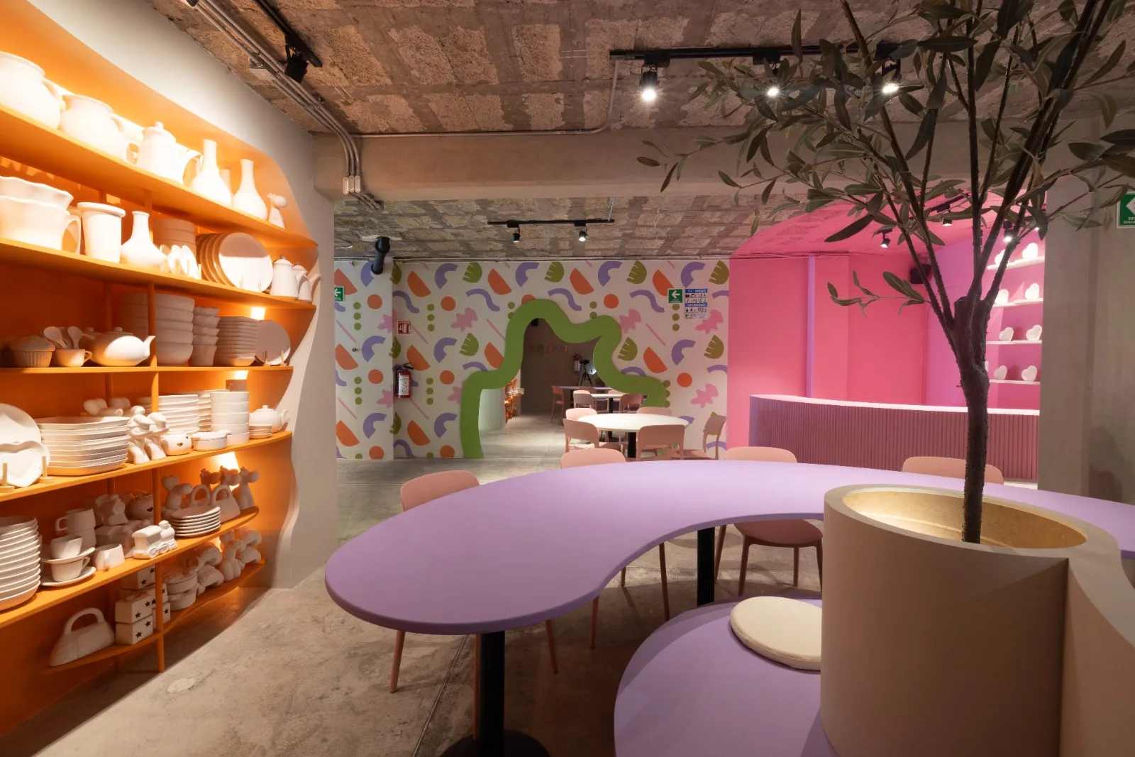 Interior del taller de cerámica CLAYZIE en Roma Norte, con formas orgánicas y colores vibrantes