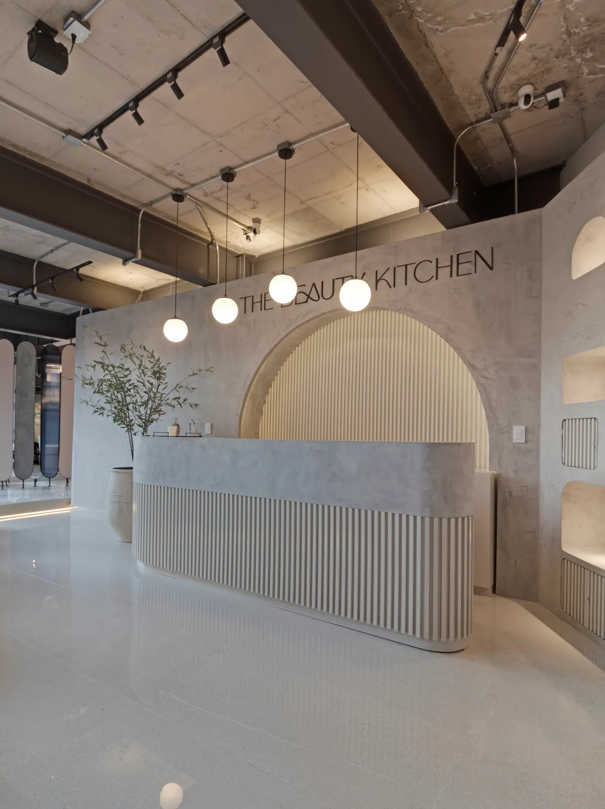 Interior de The Beauty Kitchen, colectivo de belleza con arcos y paleta monocromática